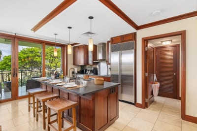 Tropical trees sway just beyond your prep space in this open-layout kitchen, designed for both ease and escape