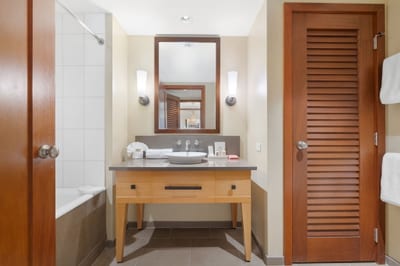 Bathe beneath soft golden light and rinse away the day in a space that feels equal parts luxury suite and beachside retreat