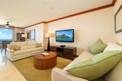 This living room is a quiet hug in beige and sage, where modern comfort meets the island’s gentle, golden glow