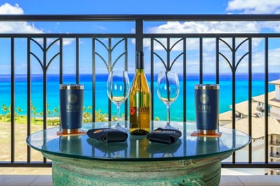Every detail sets the scene—from custom tumblers to a bottle of wine—all against the turquoise canvas of the sea