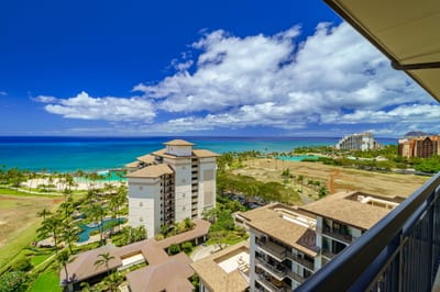 From your balcony in the clouds, the ocean stretches like a shimmering quilt, stitched in blues and kissed by sun