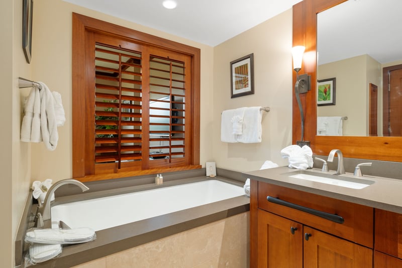 Soak under soft lighting in a tub with a view—those shuttered windows aren't just pretty, they’re peekaboo perfection    