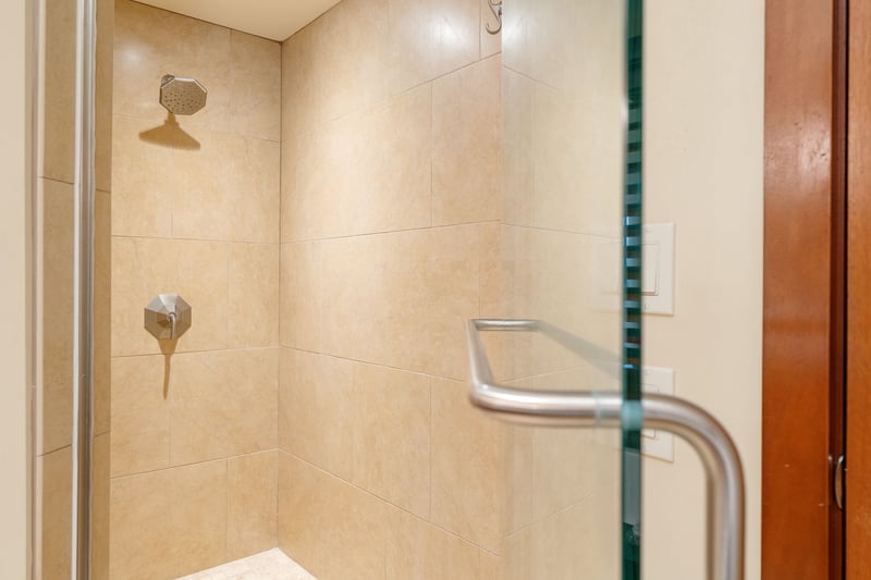  The walk-in shower stands ready like a sandstone throne room, awaiting its next royal rinse ceremony   