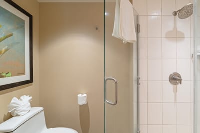 Even the toilet gets the luxury treatment here—topped with a bow-tied towel and watched over by breezy artwork