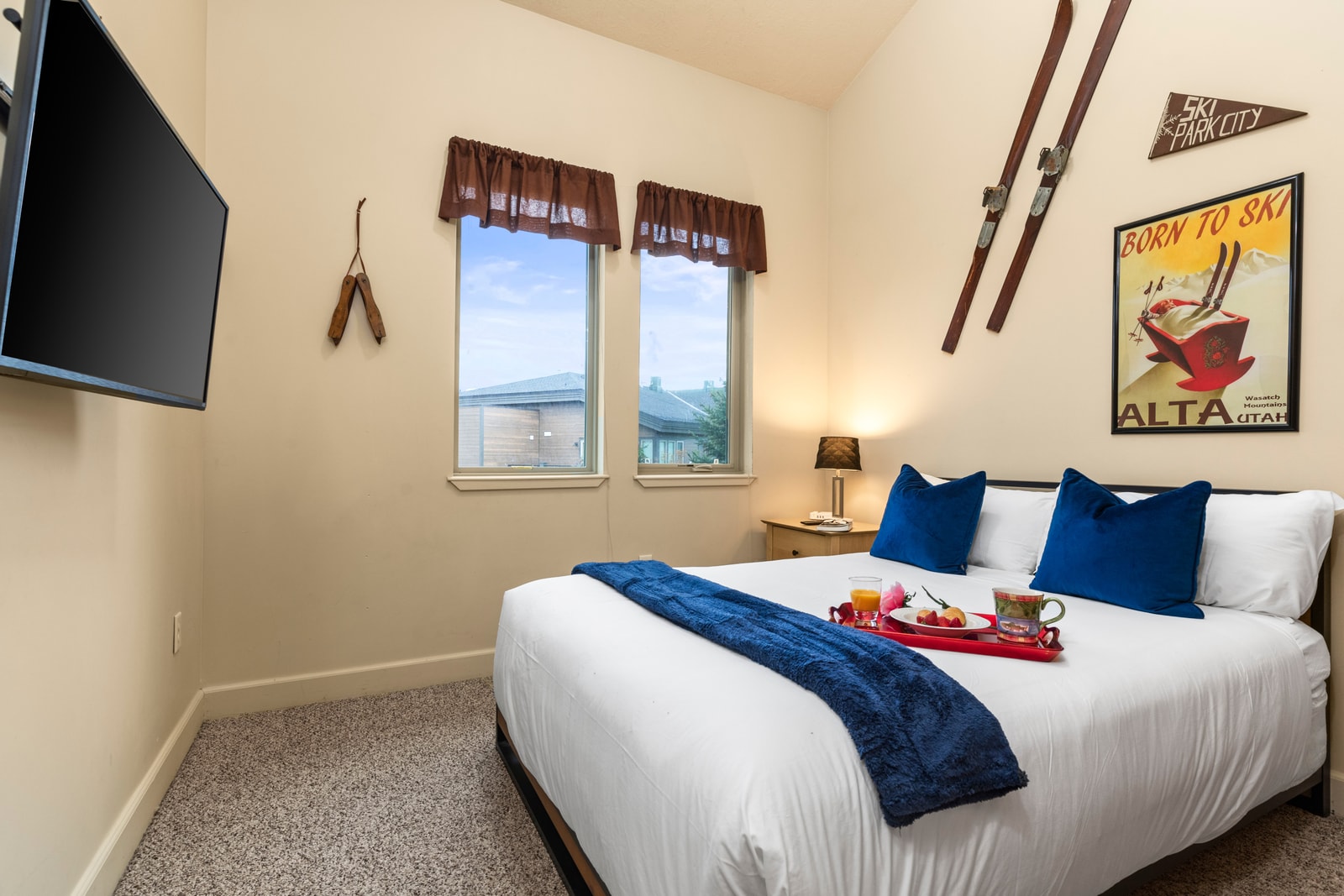 Large windows and TV in the Queen bedroom offer comfort and convenience.
