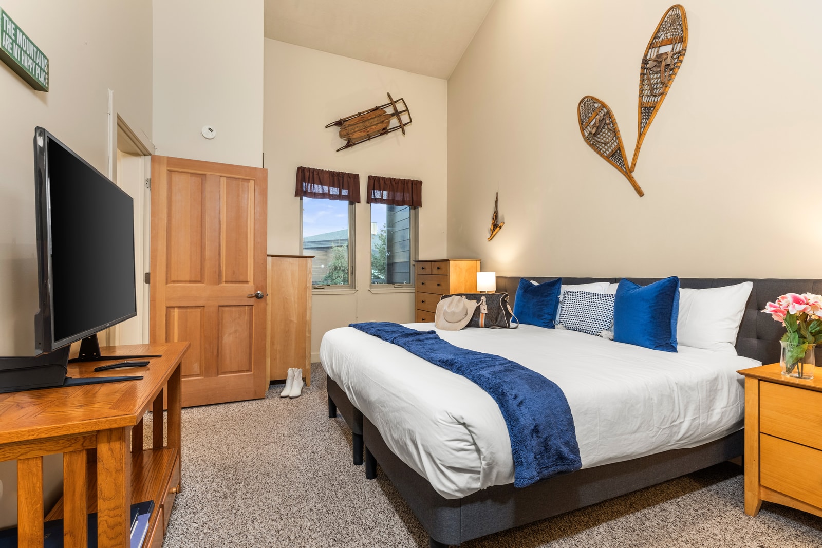 Primary bedroom features a King bed (or two Twins by request), vaulted ceilings, and private balcony access.