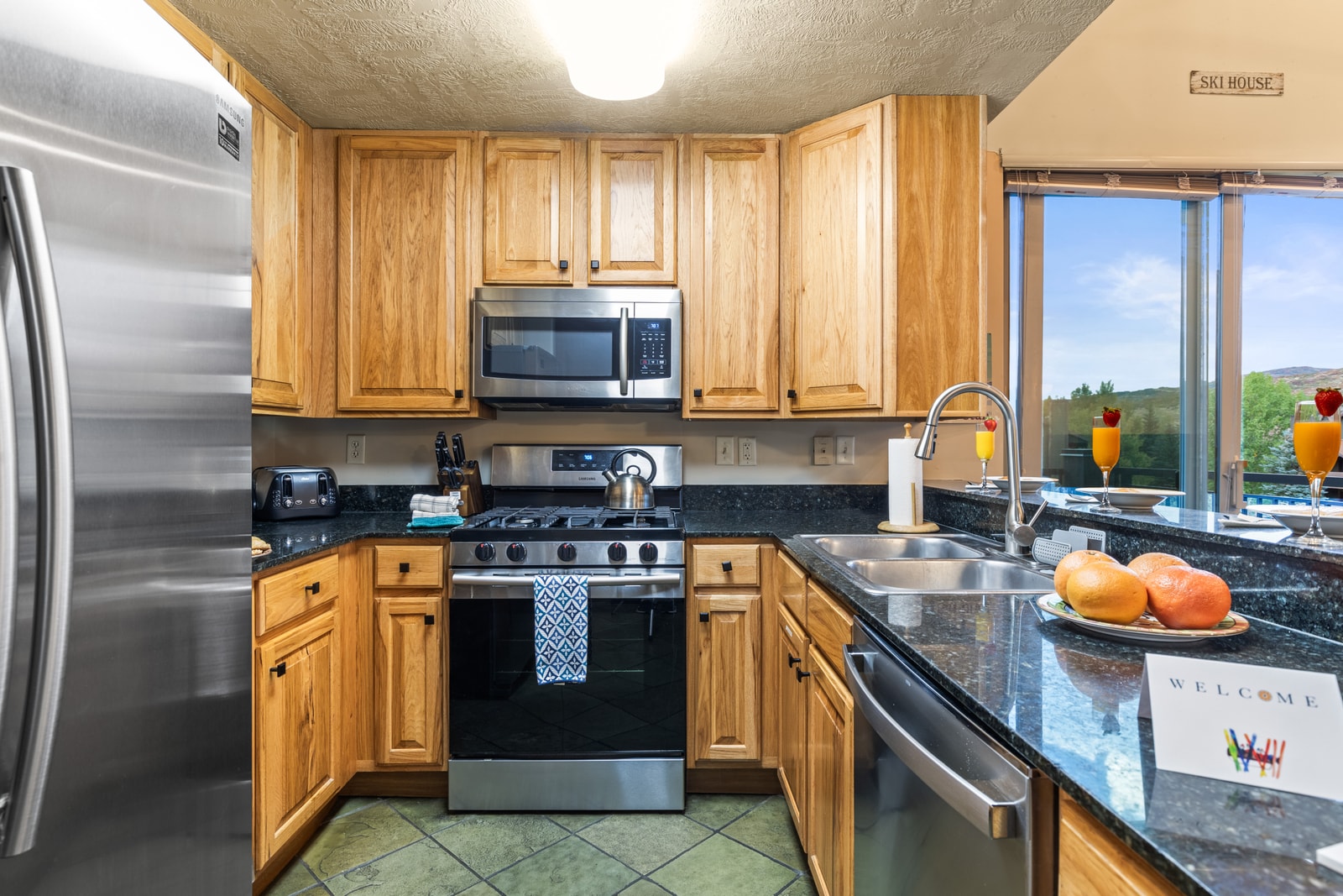 Fully equipped kitchen with granite counters, gas range, and stainless appliances makes dining in effortless.