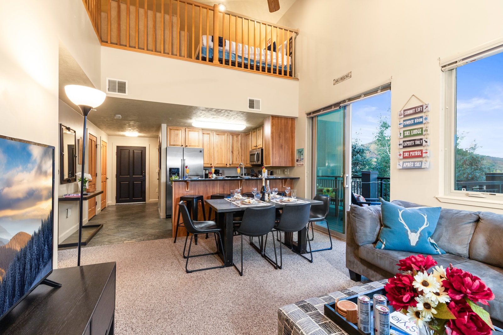 Soaring ceilings and an open loft above give this living space a grand, airy feel.