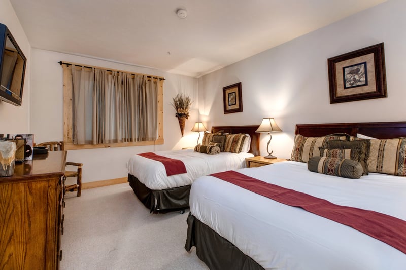 Guest Bedroom includes two Queen beds, large window, and warm lighting for restful nights.