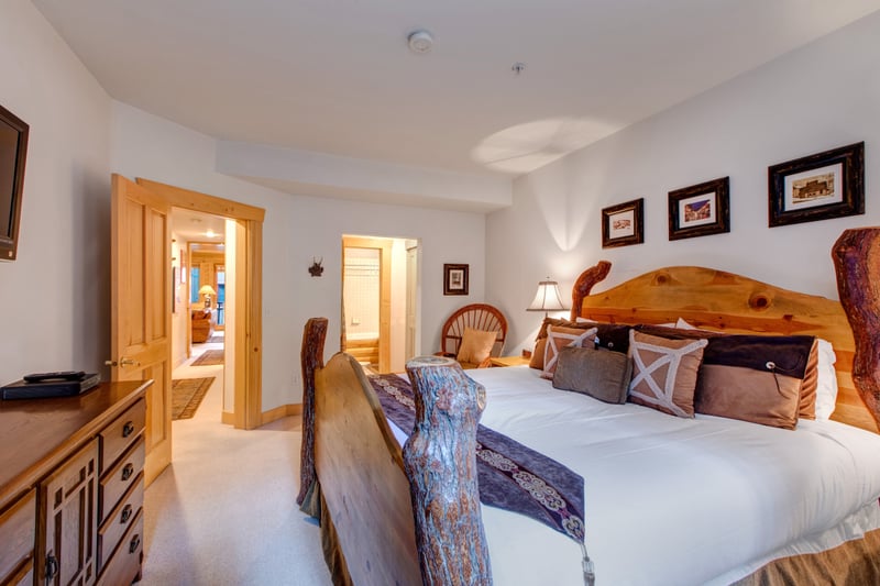 A second view of the primary bedroom showing seating area and ensuite access.