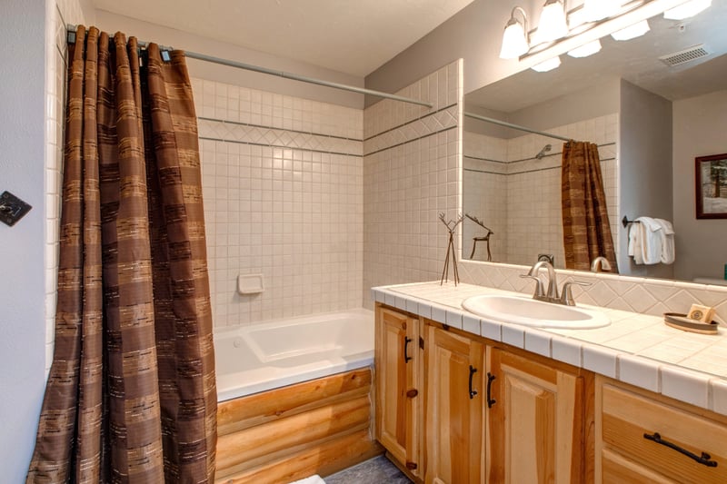 Primary ensuite with granite double vanity and shower-tub combo.
