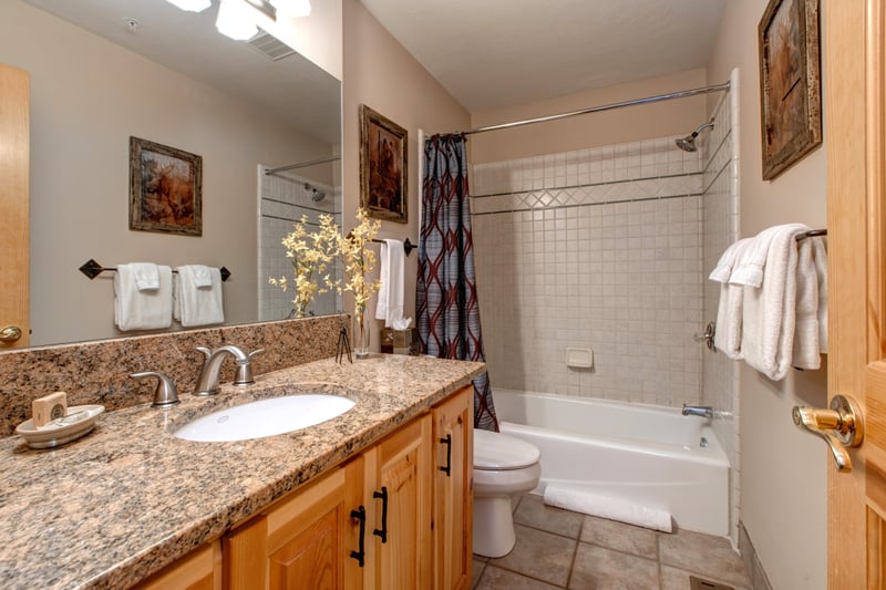 Third full bath includes granite counters, a tub-shower combo, and hallway access for guests.