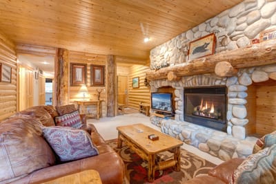 Enjoy conversations around the fireplace in this lodge-style living room with wood accents throughout.