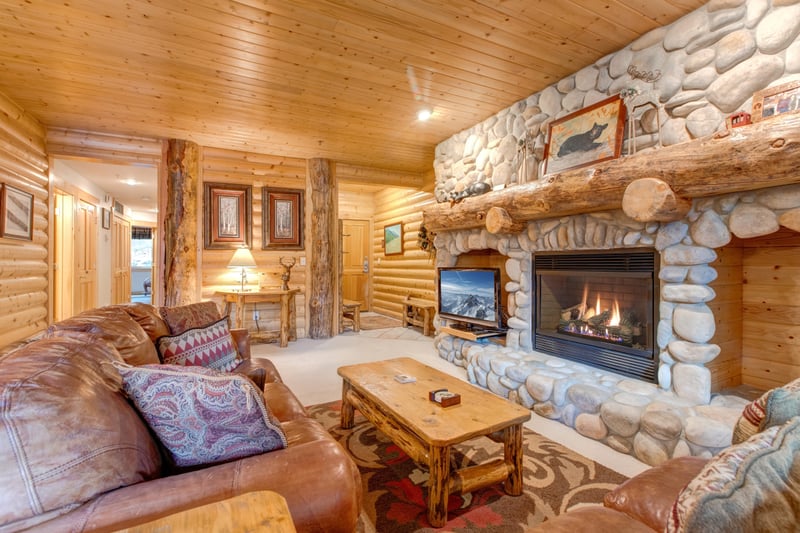 Enjoy conversations around the fireplace in this lodge-style living room with wood accents throughout.