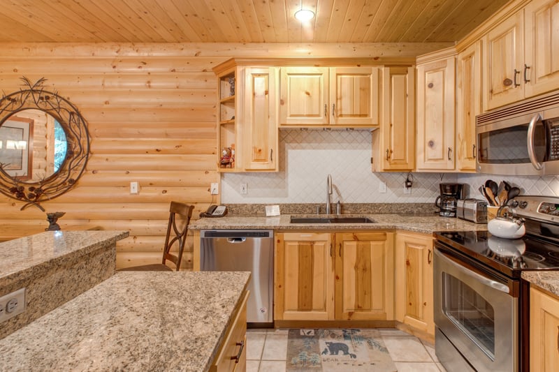 Kitchen island with granite counter, bar seating, and easy access to dining and living areas.