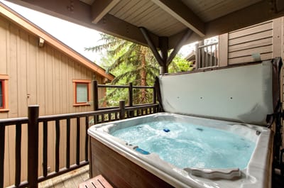 Enjoy a relaxing soak in your private outdoor hot tub tucked beneath a covered balcony.