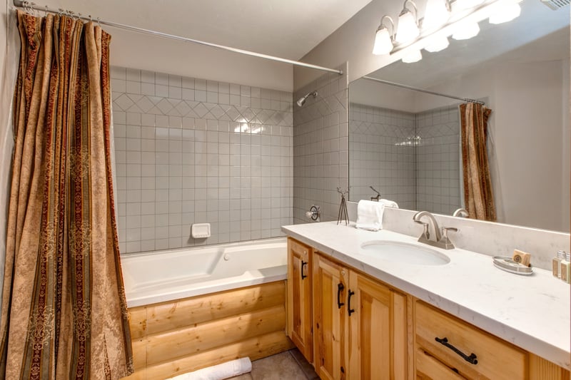 Another angle of Guest Bath 1 highlights the full tub-shower combo and rustic design.