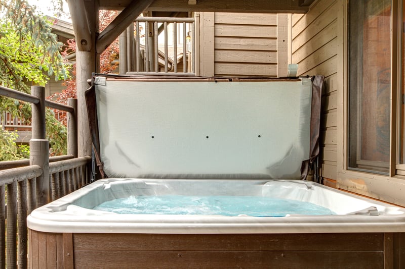 Covered hot tub on the balcony offers privacy and fresh mountain air after a day out.