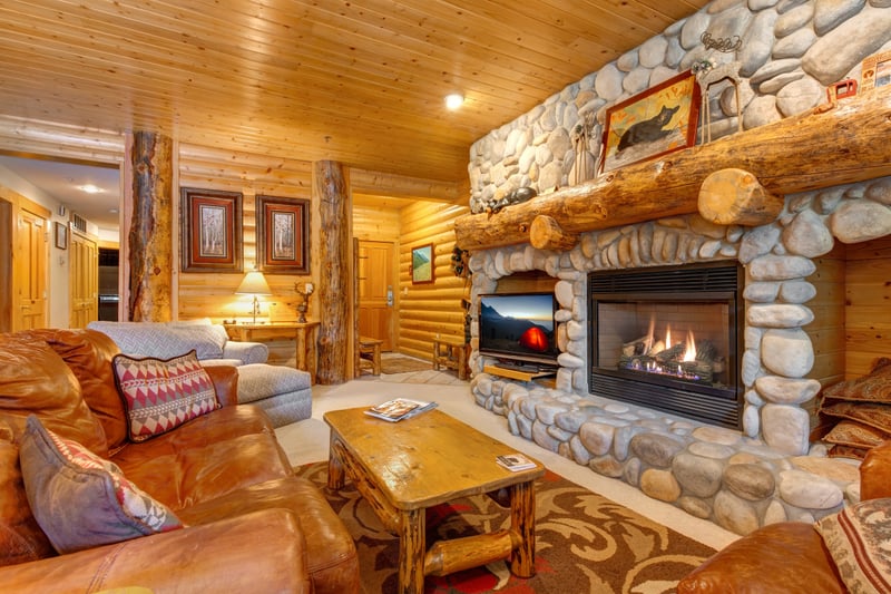 Stone fireplace and log-style details create a cozy living space with alpine character.