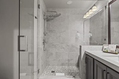 The guest bath with sleek tile and vanity offers comfort and privacy for your group.