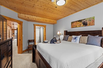 Spacious guest room with a King bed and wood-paneled walls, perfect for peaceful nights. BBL-351A