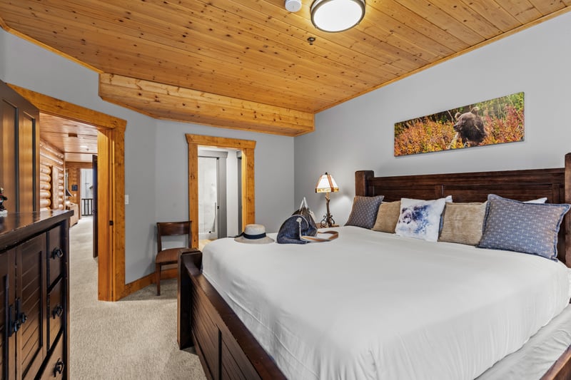 Spacious guest room with a King bed and wood-paneled walls, perfect for peaceful nights. BBL-351A
