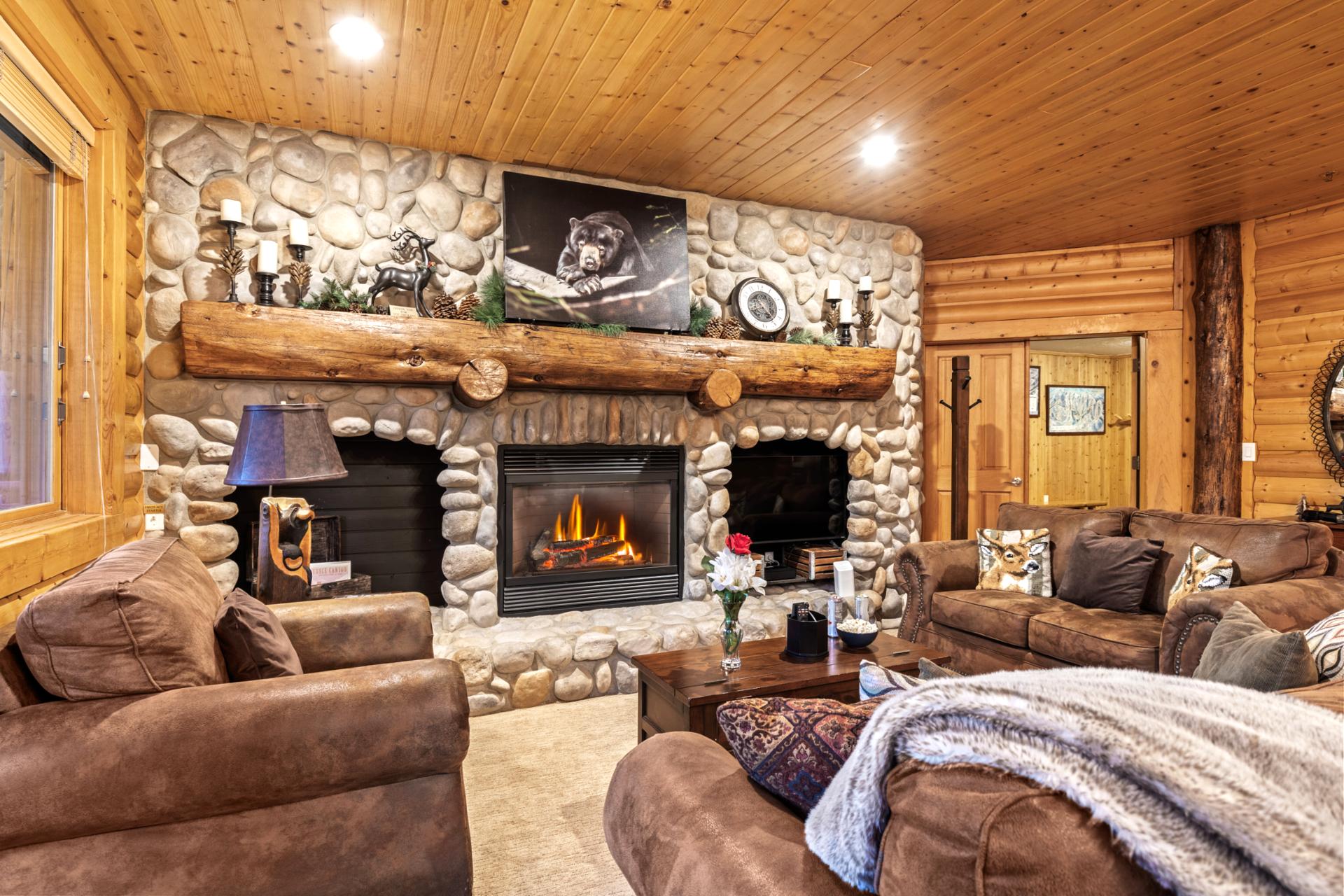 Relax in the main living area, where exposed beams and leather furnishings create a cozy mountain lodge vibe.