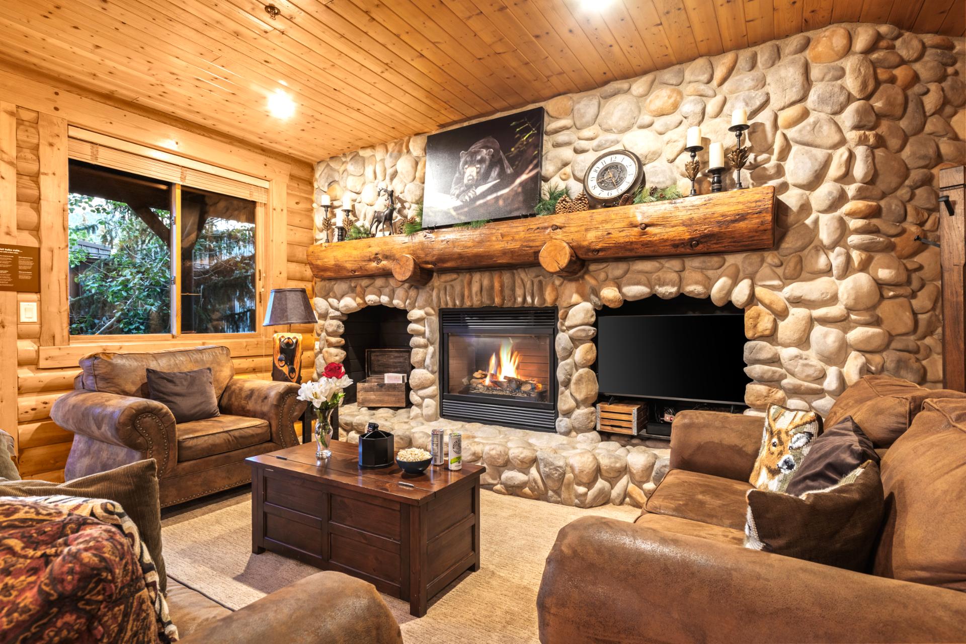 Your living room offers lodge-style comfort with a stone fireplace, flat-screen TV, and plenty of plush seating for movie nights or game days.