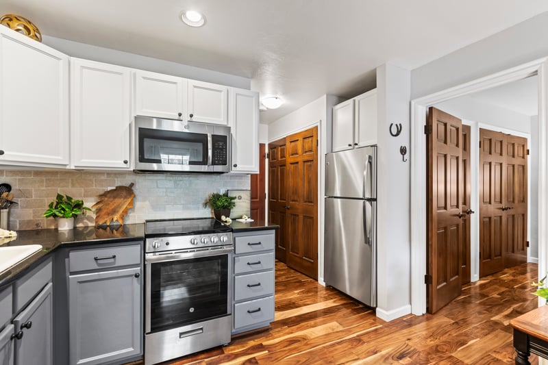 Granite countertops and stainless oven, microwave, and fridge appliances bring modern convenience to this compact kitchen.