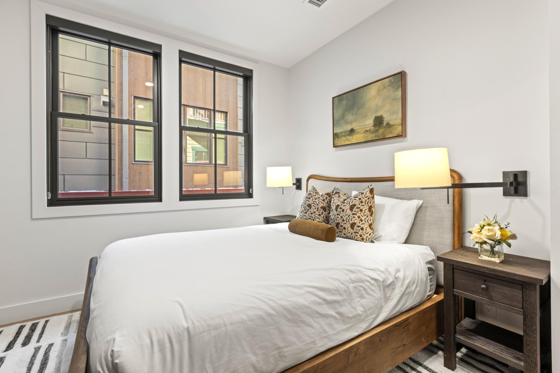 This alternate angle shows generous natural light and neutral decor in the Queen suite.