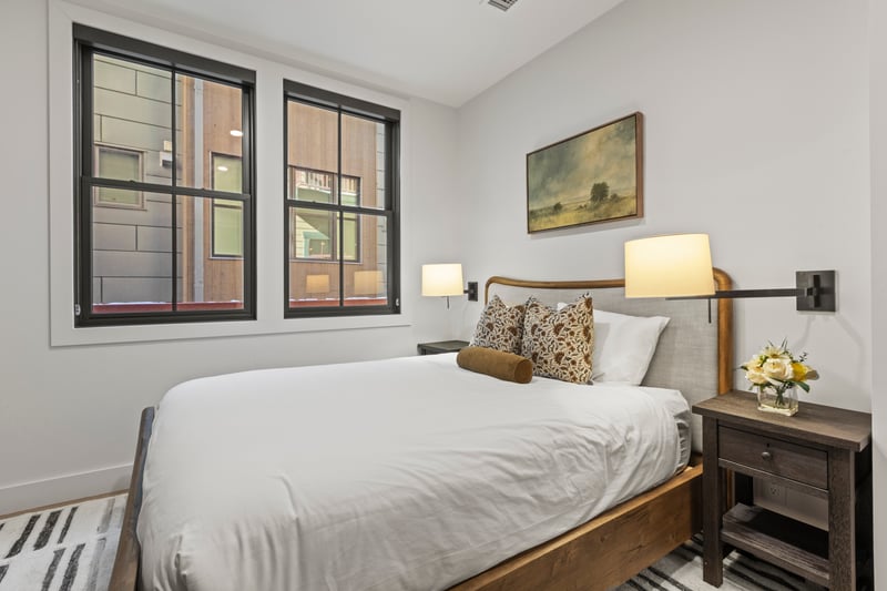 This alternate angle shows generous natural light and neutral decor in the Queen suite.