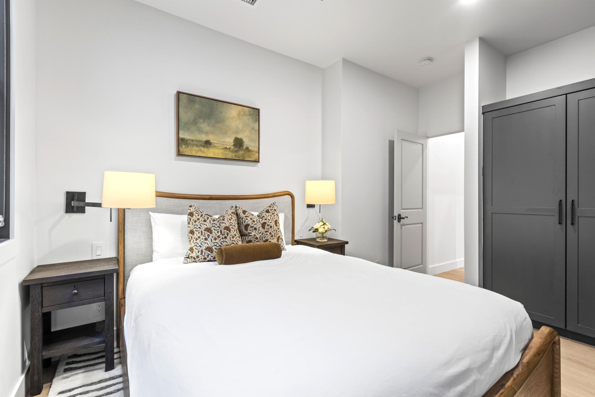 Rest easy in the Queen bed with side lighting and soft neutral tones, just steps from the main bath.