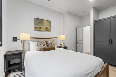 Rest easy in the Queen bed with side lighting and soft neutral tones, just steps from the main bath.