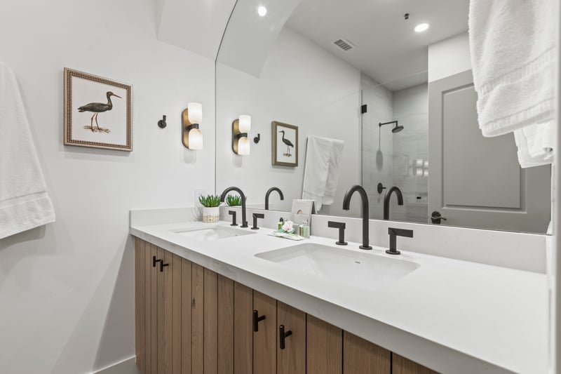 This full bath includes dual sinks, step in shower and sleek fixtures.