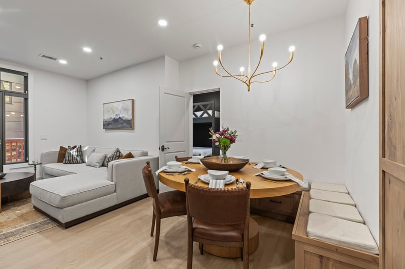 Alternate angle of the dining area shows seamless layout and inviting light fixture.