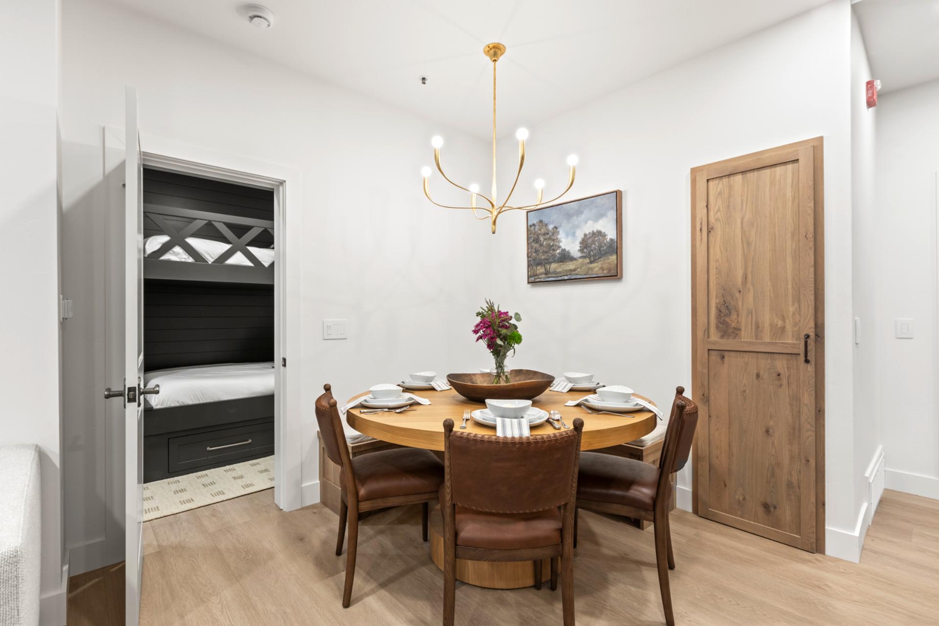 Dining table set for four, nestled between the kitchen and hallway, perfect for sit-down meals.