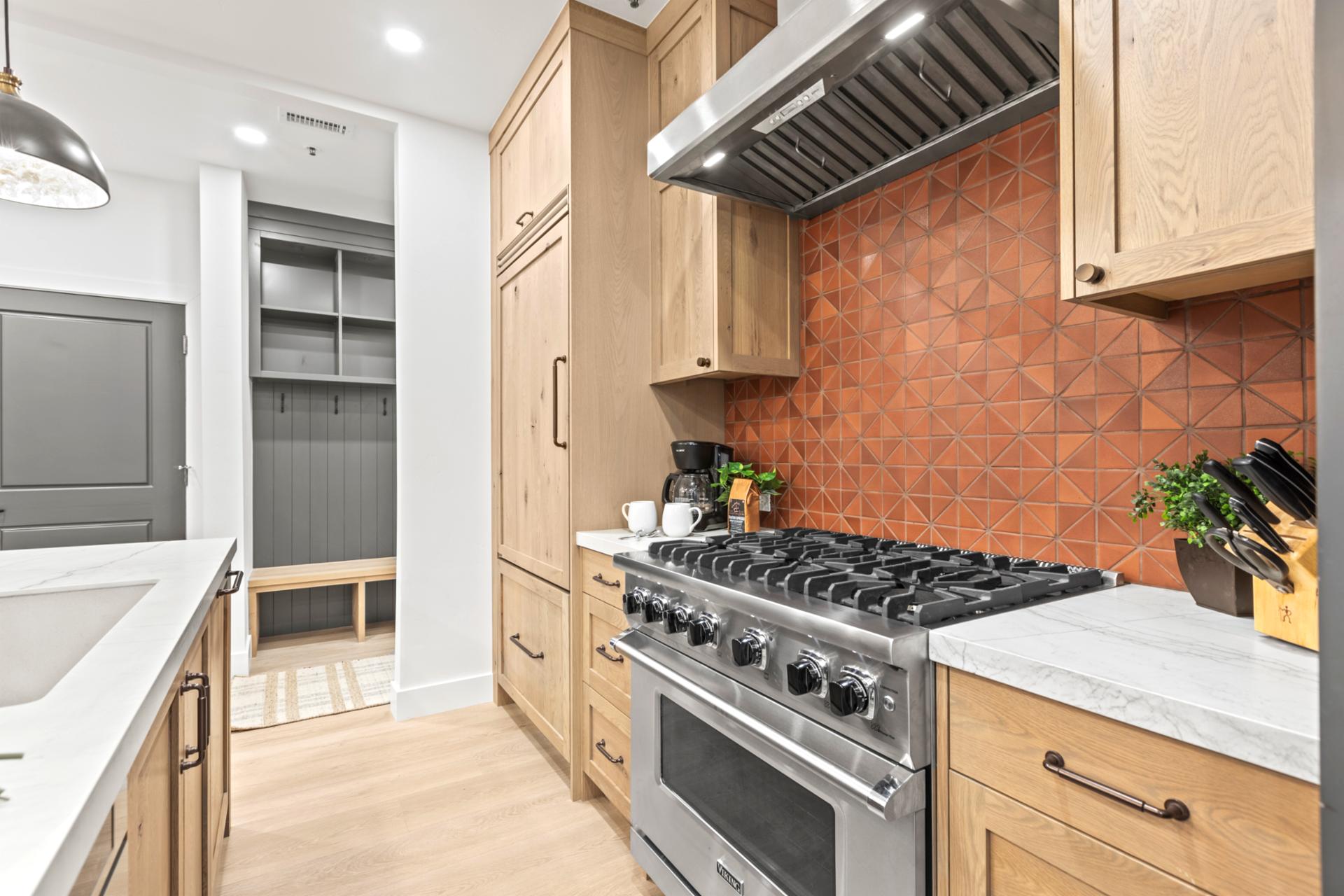 Your kitchen includes high-end appliances, open shelving, and a gas range with striking tile backsplash.