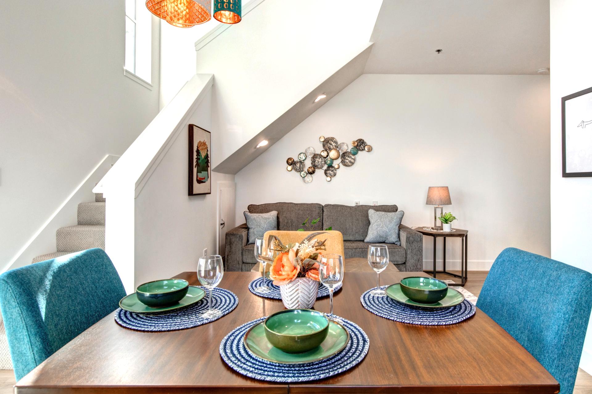 Colorful chairs and modern tableware add a pop of style to this bright, inviting dining area.