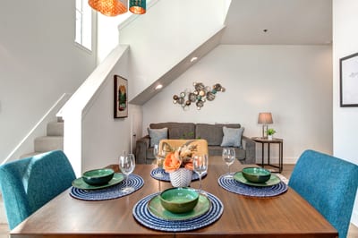 Colorful chairs and modern tableware add a pop of style to this bright, inviting dining area.