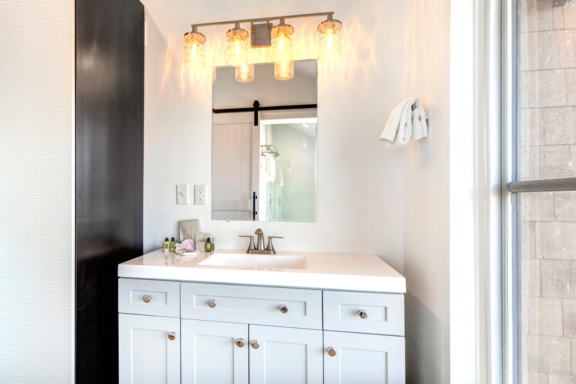 Your primary bath includes a bright double vanity and step-in shower with elegant tile and glass.