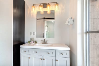 Your primary bath includes a bright double vanity and step-in shower with elegant tile and glass.