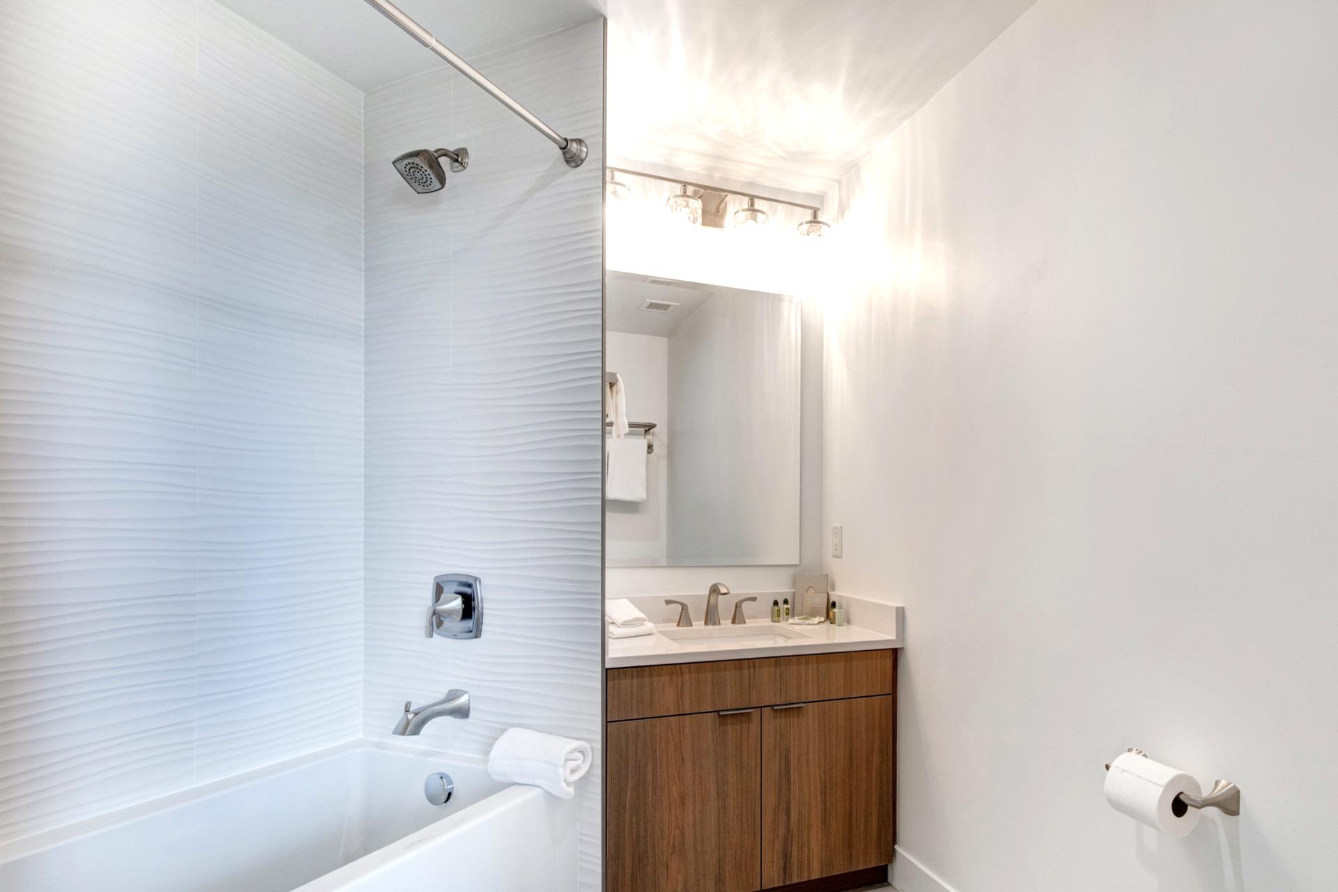Bright lighting and wood finishes make this guest bath both stylish and practical.