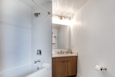 Bright lighting and wood finishes make this guest bath both stylish and practical.