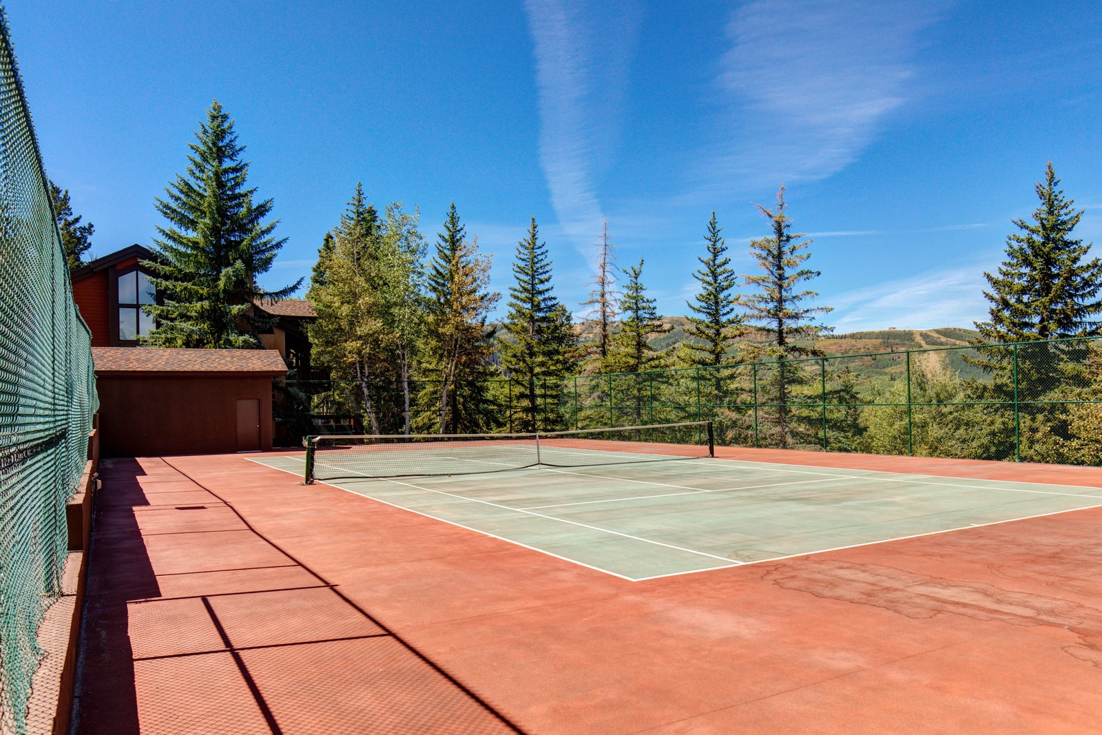 Play a match on the shared tennis courts surrounded by mountain views.