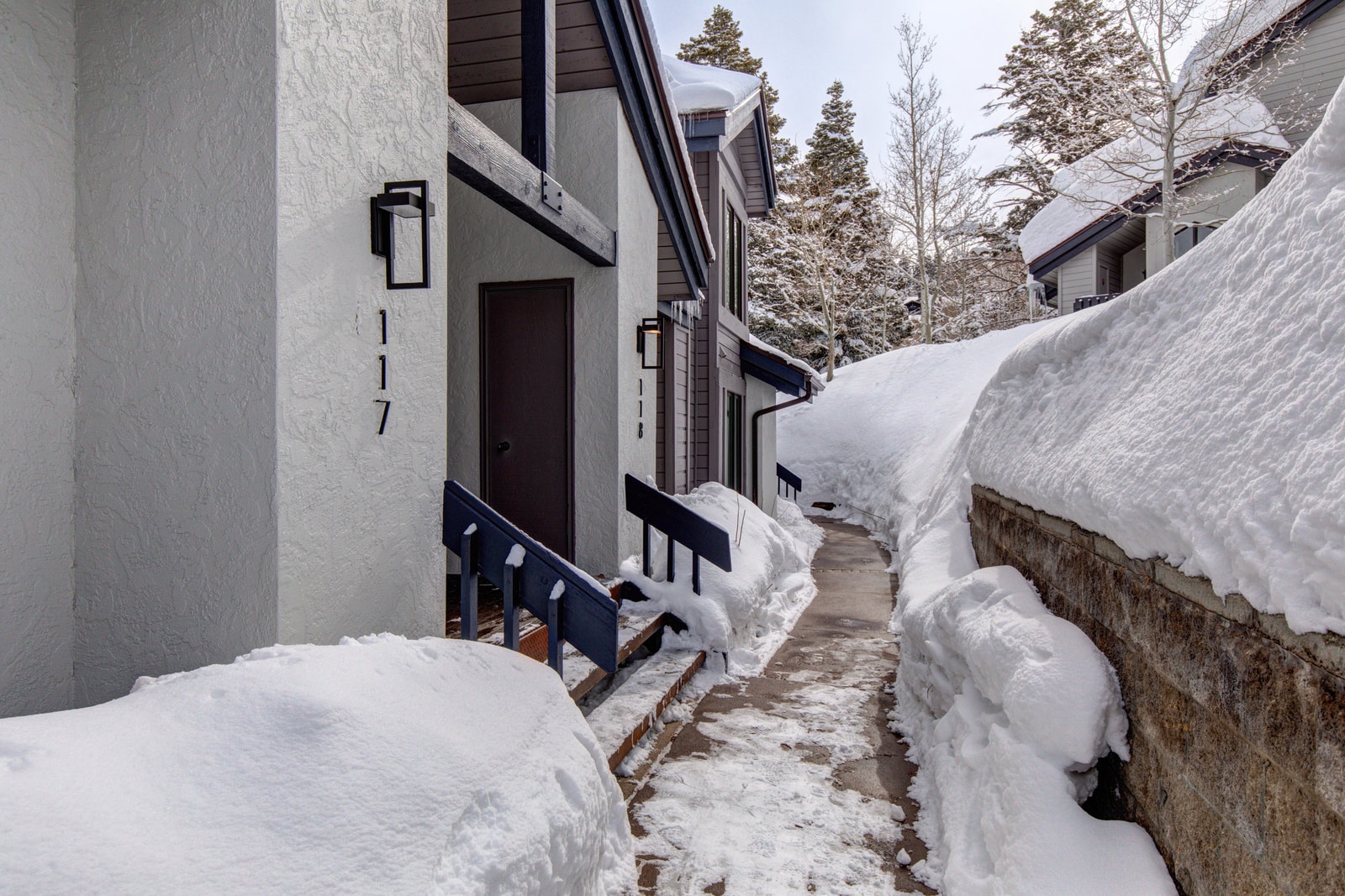 A clear, shoveled path leads to your cozy mountain escape.