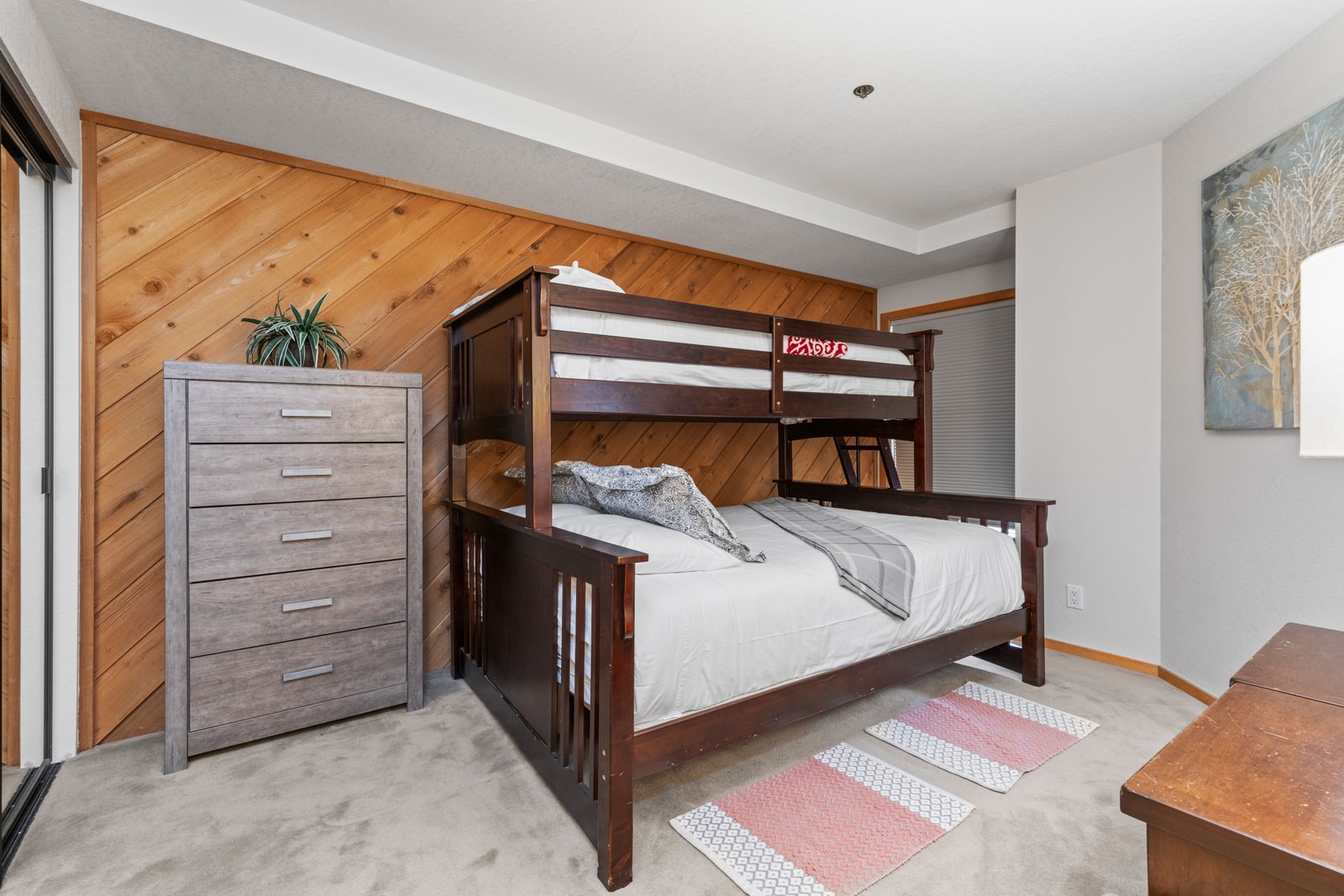 The bunk room features a Twin-over-Queen setup with storage and colorful decor.