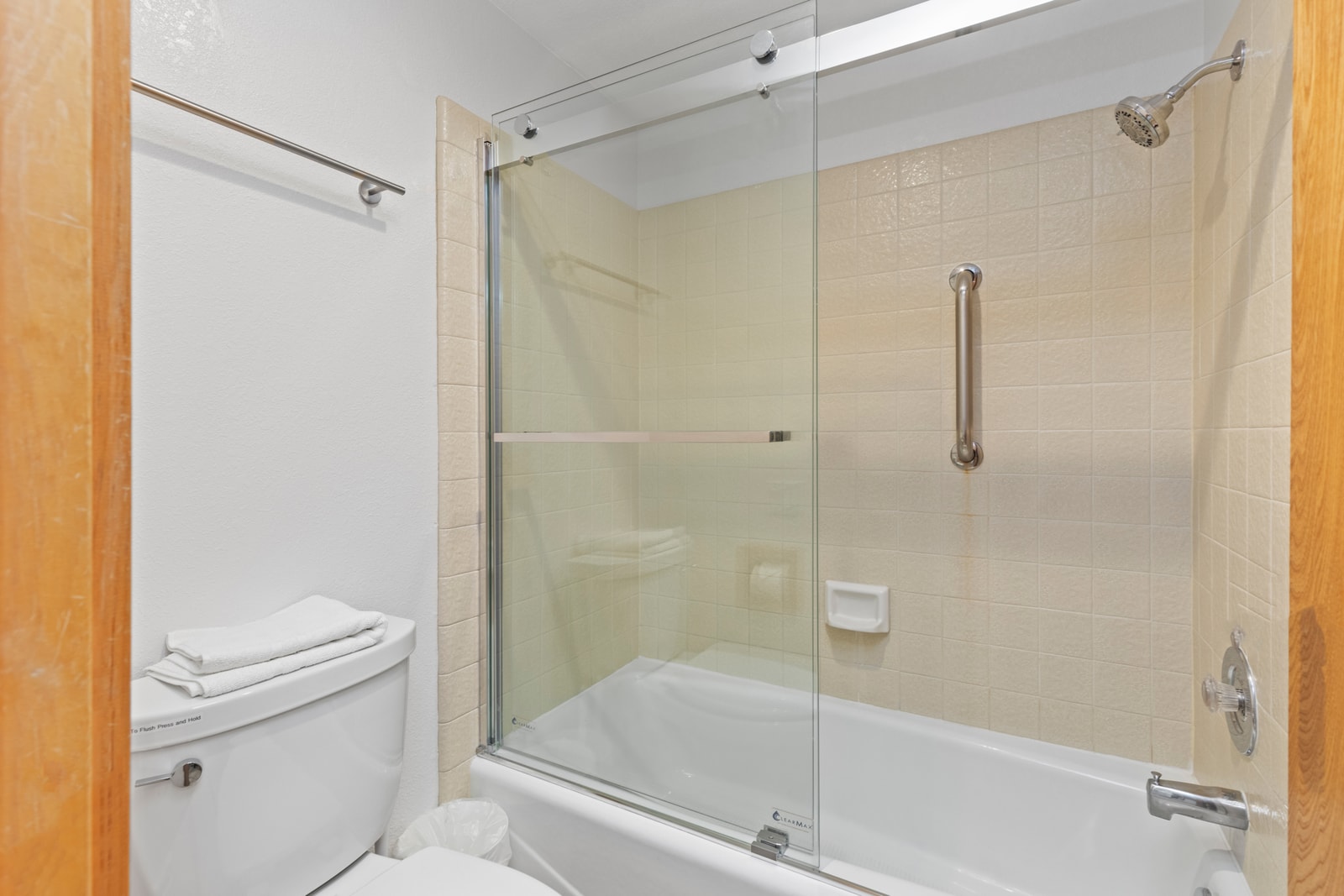 Tile tub surround and natural finishes elevate this shared bath serving Bedrooms 2 and 3.