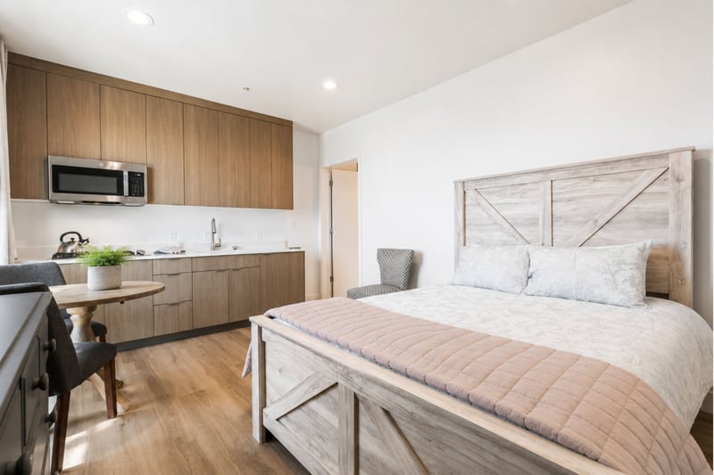 This guest suite pairs a plush queen bed with a built-in kitchenette, ideal for guests who want a bit of independence.
