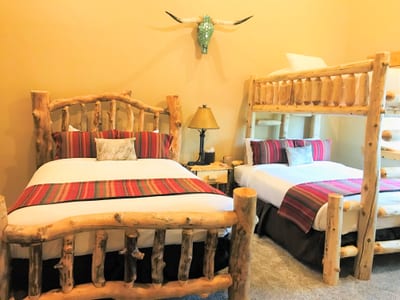 The second bedroom includes two Queen beds and a bunk, creating a flexible space for kids or friends.
