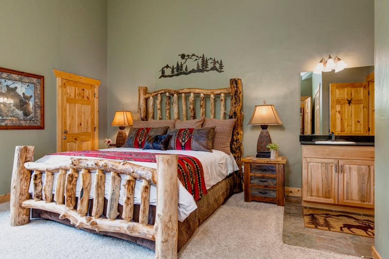 Primary bedroom with King bed and warm wood furnishings provides a peaceful space to rest upstairs.